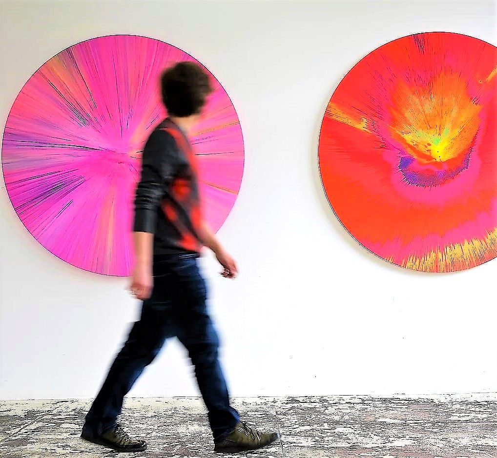 Zwei große runde 120-cm-Spin-Paintings mit einer Person im Vordergrund