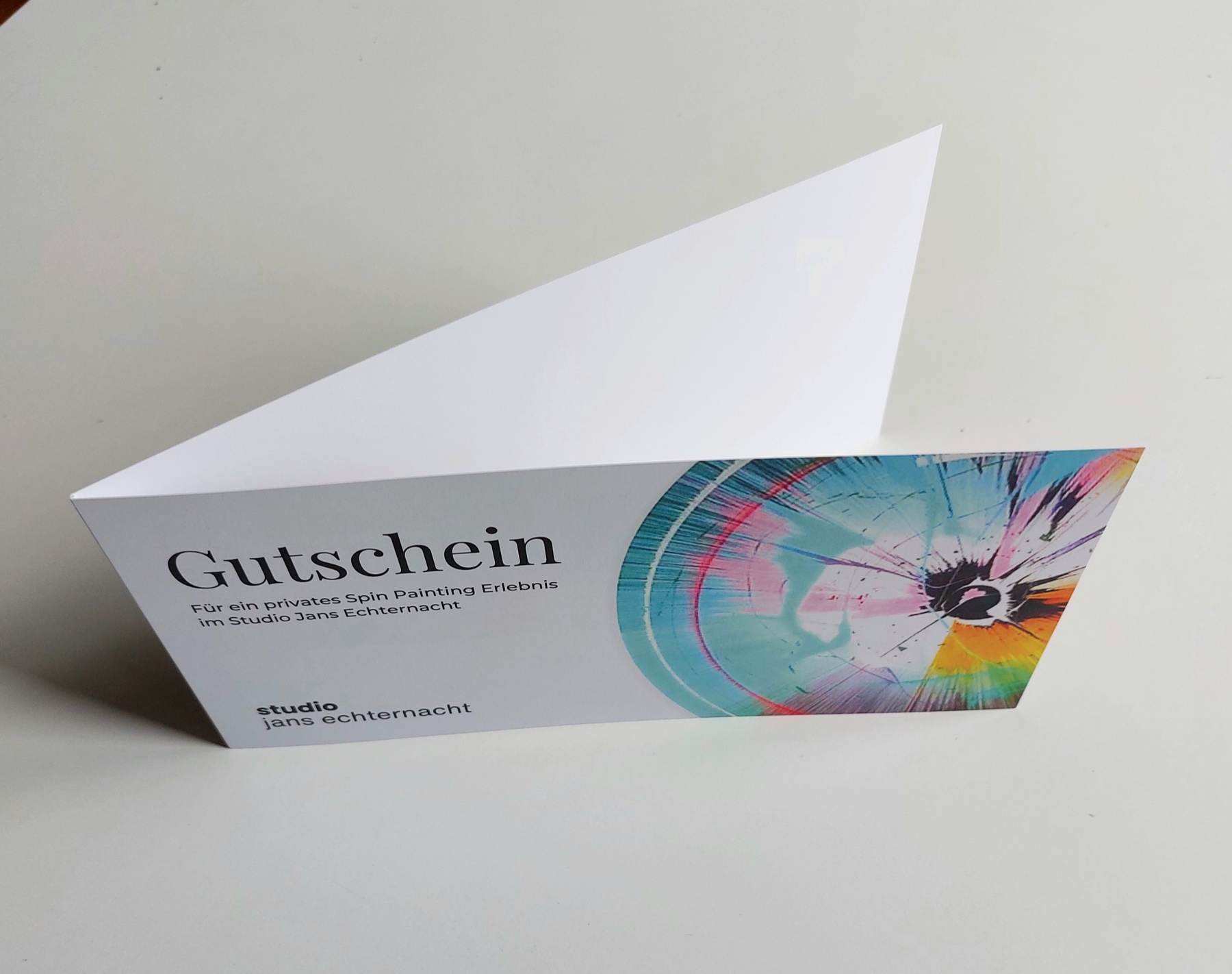Geöffnete gedruckte Gutschein-Klappkarte für ein Spin Painting Erlebnis