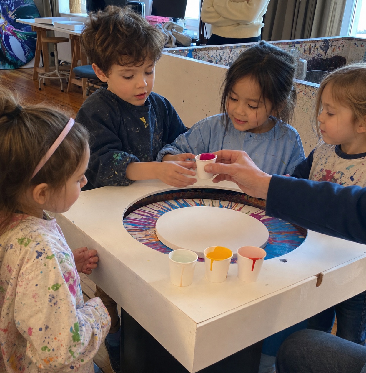 Kinder malen an der kleinen Spin-Art-Maschine im Studio Jans Echternacht