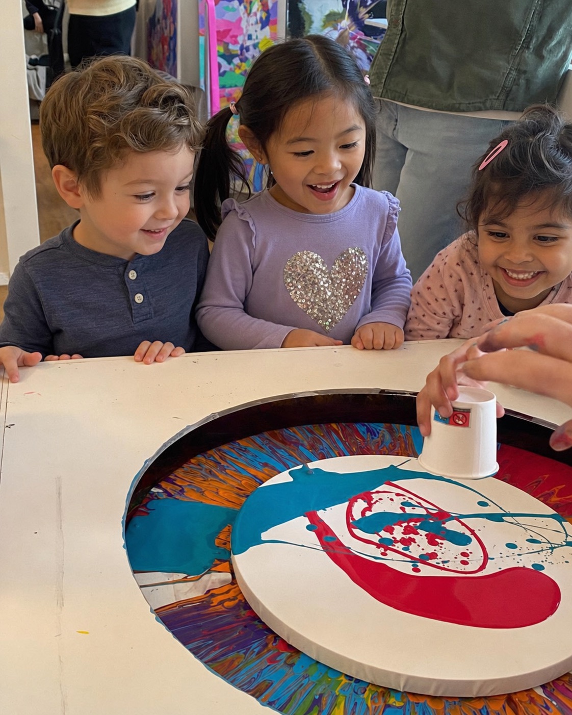 Group of children creating a spin painting together at the Berlin studio