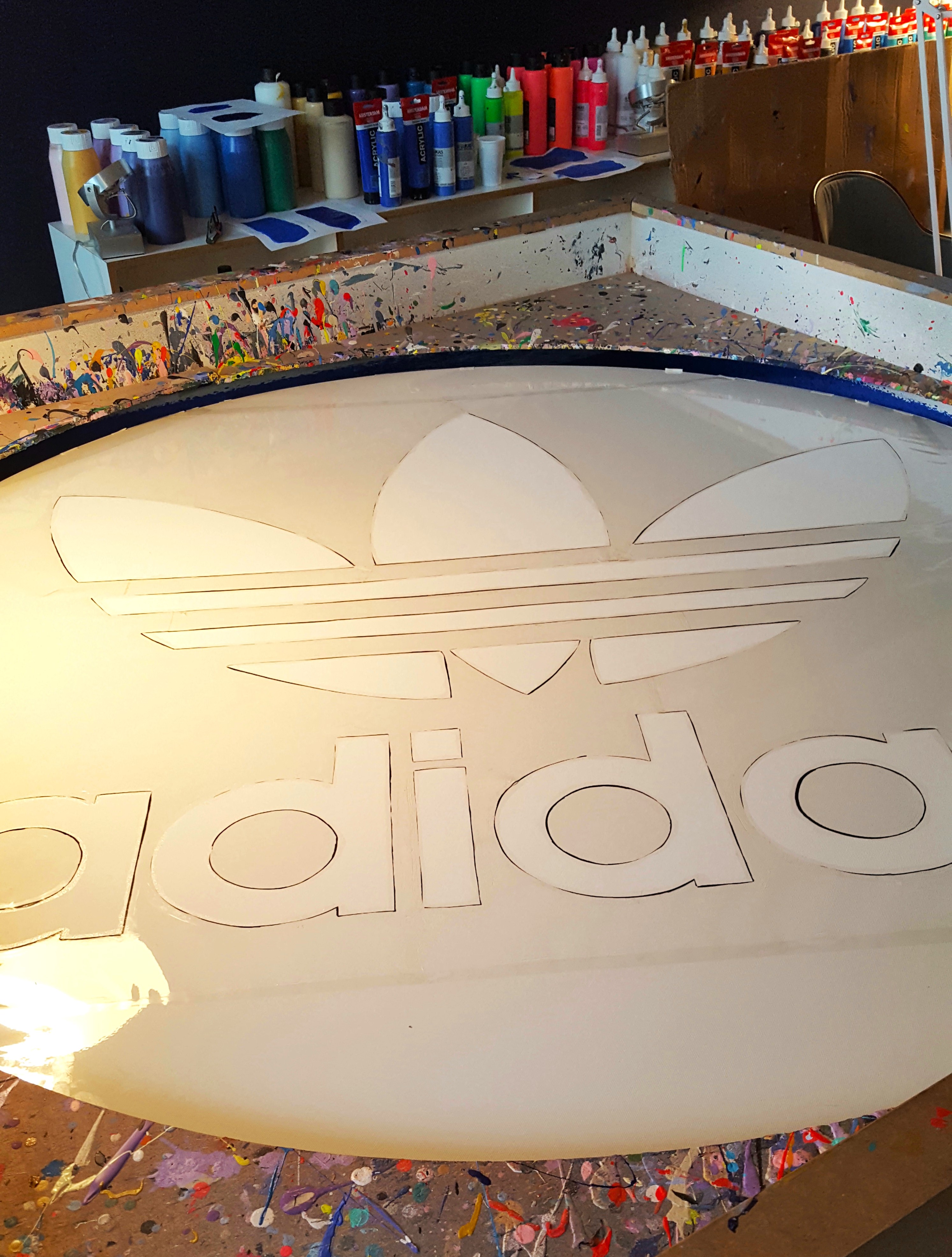 Preparing the Adidas emblem on a round canvas