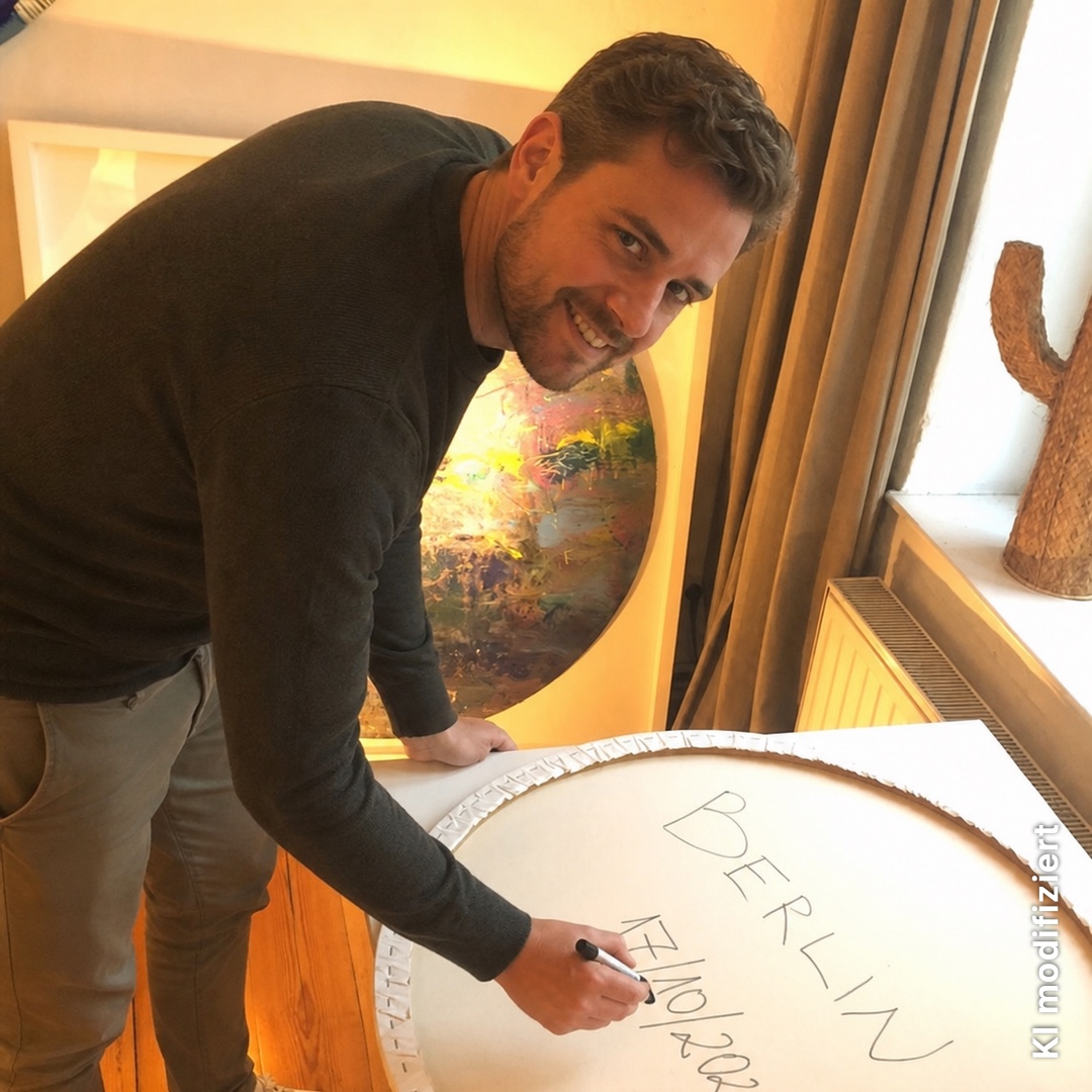 Teilnehmer signiert die Rückseite seines Spin Paintings mit Berlin und Datum